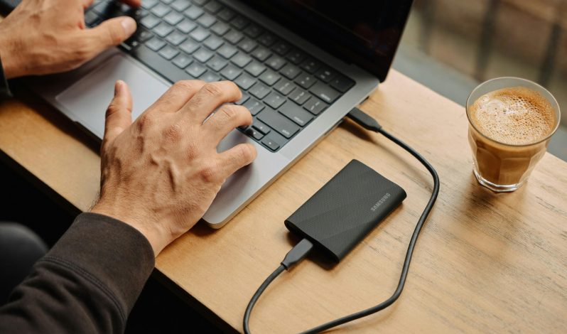 A man sitting at a table using a laptop computer