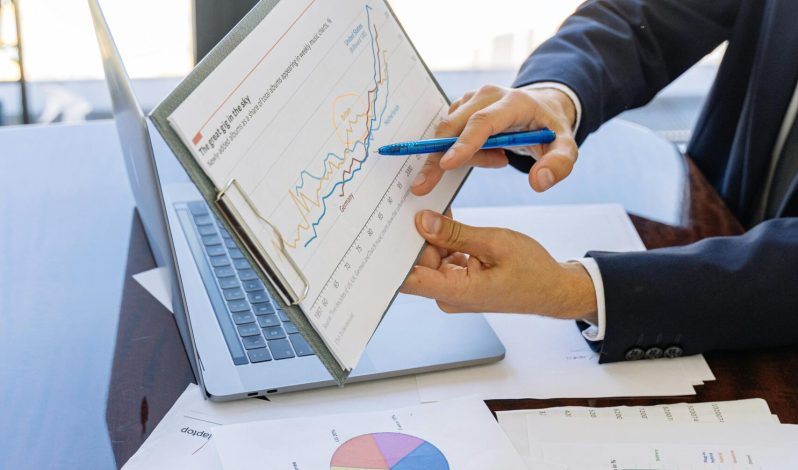 Free Business professionals discussing financial graphs and charts in an office setting. Stock Photo
