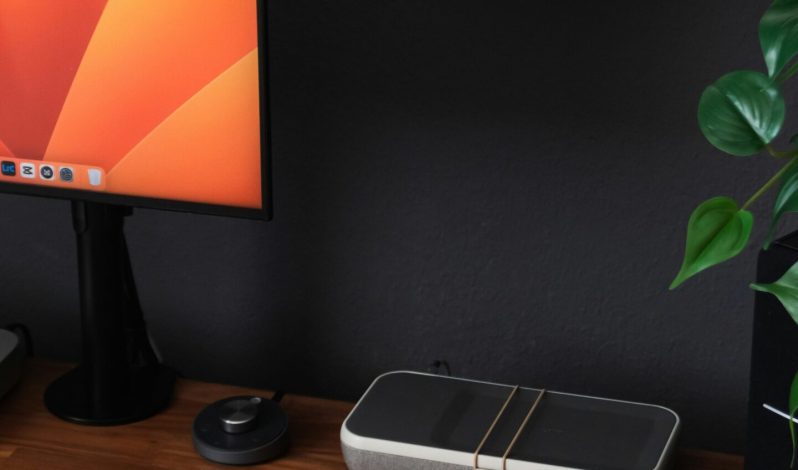 a desk with a laptop, keyboard, mouse and a monitor