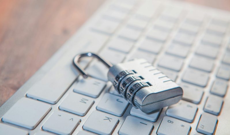 A combination lock rests on a computer keyboard.