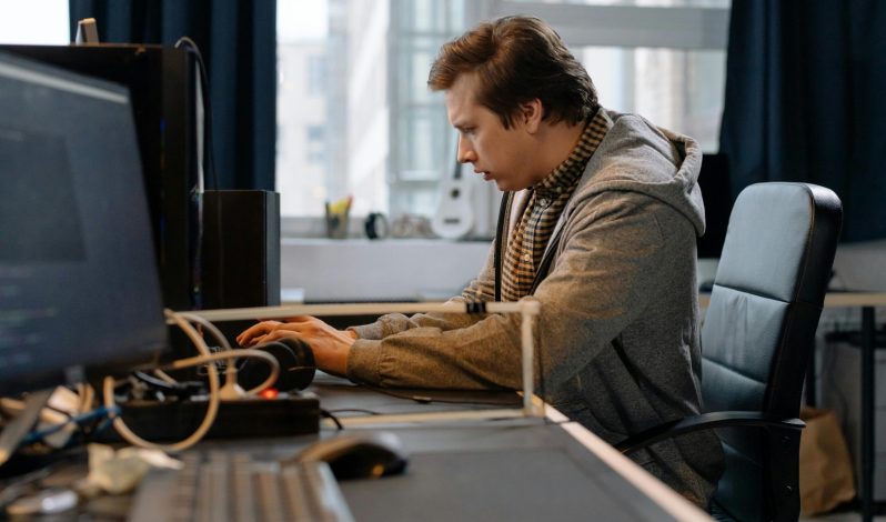 Free A concentrated professional working at a computer in a modern office setting. Stock Photo